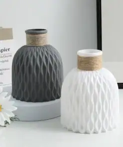 Two textured vases, one gray and one white, with rope details on top; daisies in foreground and paper decor in background. | 28Alchemy