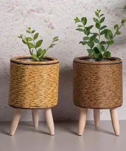 Two small plants in Rattan Planter Stands stand against a textured wall. | 28Alchemy