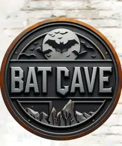A round metal sign with "BAT CAVE" text, a bat silhouette, mountains, and flying bats, against a white brick wall. | 28Alchemy