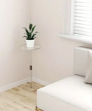 A small white potted plant sits on a clear glass side table in the corner of a bright, minimalist living room. | 28Alchemy