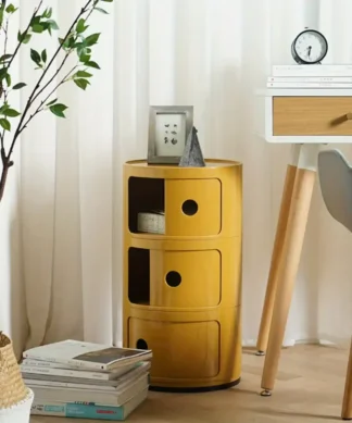 Yellow round storage cabinet with three drawers beside a desk, books, a plant, and a woven basket. | 28Alchemy