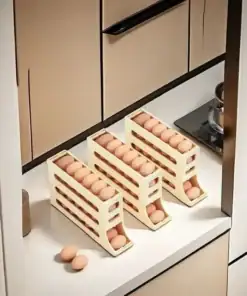 Three beige egg dispensers filled with eggs are arranged on a kitchen counter, with two eggs placed nearby. | 28Alchemy