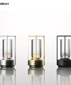 Three modern lantern-style table lamps in silver, gold, and black, displayed on a reflective surface. | 28Alchemy