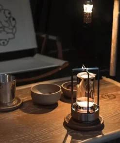 A cozy wooden table with a lantern, bowls, a metal cup, and a hanging lamp, softly lit at night. | 28Alchemy