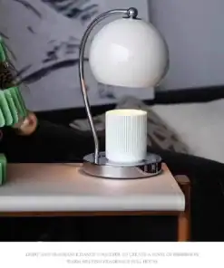 Modern white table lamp on a bedside table, next to a green decor item, with minimalist decor in the background. | 28Alchemy
