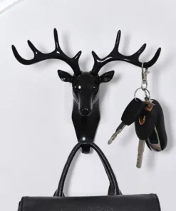 Black deer head wall hook holding keys on an antler and a black handbag on the lower hook against a white wall. | 28Alchemy