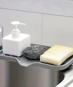 Grey sink tray holding a soap dispenser, a metal scrubber, and a yellow sponge next to a faucet. | 28Alchemy
