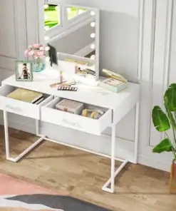White vanity table with lit mirror, two open drawers, makeup, jewelry, framed photo, and a green plant nearby. | 28Alchemy