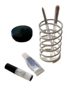 A set of makeup items: two brushes in a metal holder, a small jar, and two tubes of cosmetics on a white background. | 28Alchemy