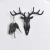 A black deer head wall hook holding a set of keys with a black key fob and two metal keys. | 28Alchemy
