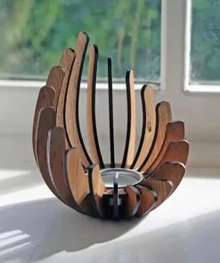 A wooden candle holder with curved slats, placed on a windowsill with sunlight streaming in. | 28Alchemy