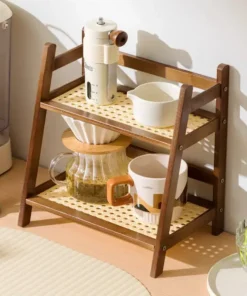 Two-tier wooden kitchen shelf holding a coffee grinder, cups, a carafe, and a white bowl on a countertop. | 28Alchemy