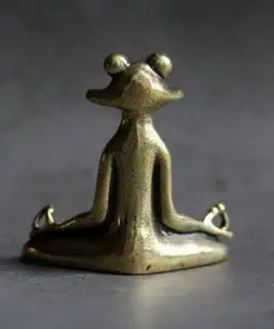Small bronze frog statue sitting cross-legged in a meditative yoga pose on a gray surface. | 28Alchemy