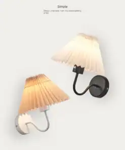 Two wall-mounted lamps with pleated shades, one with a black base and the other with a white base, against a white background. | 28Alchemy