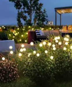 Glowing garden lights dot green bushes at night near an outdoor seating area with trees and cozy furniture. | 28Alchemy