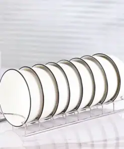 Seven white plates with black rims neatly arranged on a metal dish rack on a white countertop. | 28Alchemy