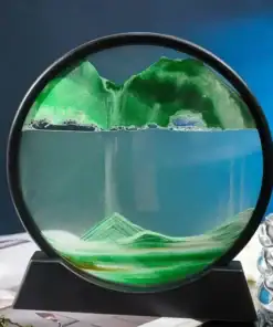 Round sand art frame with green sand forming landscape-like layers, set against a blue background. | 28Alchemy