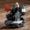Miniature incense waterfall burner with a red tree, lantern, and smoke cascading down rocky steps on a wooden surface. | 28Alchemy