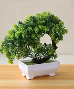 A small artificial bonsai tree with lush green leaves in a white rectangular pot on a wooden surface. | 28Alchemy
