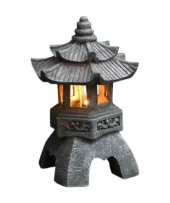 A stone Japanese pagoda lantern with a lit interior, featuring intricate roof and base details, isolated on white. | 28Alchemy