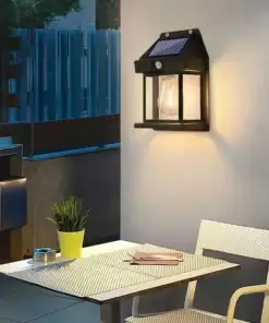 A solar wall light illuminates a patio with a table, chairs, and a potted plant at dusk. | 28Alchemy