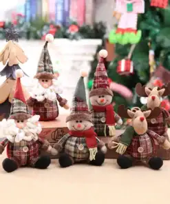 Plush Santa, snowmen, and reindeer dolls in plaid outfits are arranged in front of a Christmas tree and decorations. | 28Alchemy