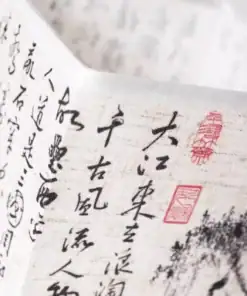 Close-up of paper with black Chinese calligraphy and red seals, slightly folded and softly lit. | 28Alchemy