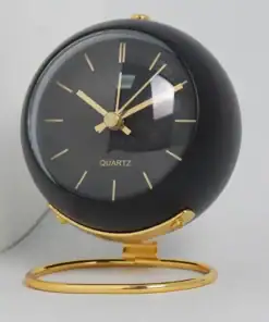 A black and gold round desk clock with gold hands and hour markers, sitting on a gold stand. | 28Alchemy