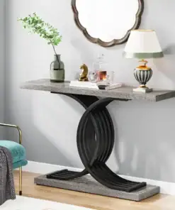 Modern console table with a curved black base, lamp, plant, and decorative items beneath a scalloped-edge mirror. | 28Alchemy