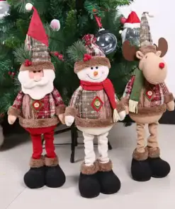 Three plush Christmas dolls—a Santa, a snowman, and a reindeer—stand in front of a decorated Christmas tree. | 28Alchemy