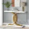 Elegant console table with a gold geometric base, marble top, lamp, plant, and decor against a gray paneled wall. | 28Alchemy