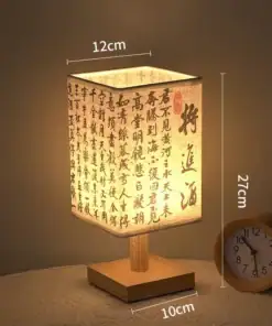 A lit rectangular lamp with Chinese calligraphy, wooden base, and a small round clock beside it on a table. Measurements shown. | 28Alchemy