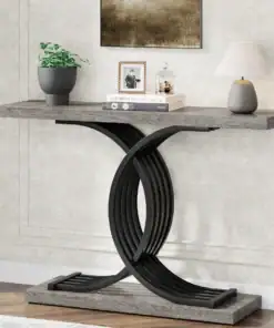 Modern console table with a unique black curved base, decorated with a plant, books, photo frame, and a small lamp. | 28Alchemy