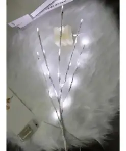White LED branch lights and a flower-shaped candle rest on a fluffy white surface with papers nearby. | 28Alchemy