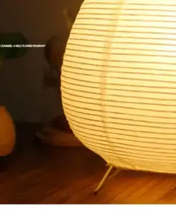 A glowing paper lantern lamp on a wooden table with a plant in the background and text on the left side. | 28Alchemy