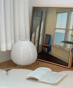 A modern room corner with a lamp, open book, potted plant, and framed painting of a chair by a sunny window. | 28Alchemy