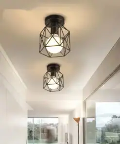 Two geometric black metal ceiling lights with white bulbs illuminate a modern hallway with large windows. | 28Alchemy