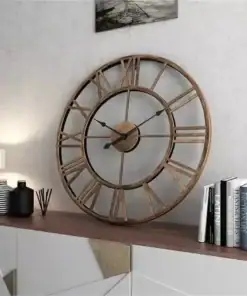 Large rustic wall clock with Roman numerals on a wooden sideboard, next to books, decor, and a lamp. | 28Alchemy