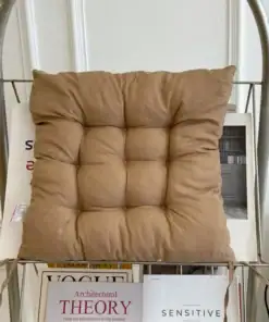 A brown tufted cushion sits on a metal rack with magazines and books displayed underneath it. | 28Alchemy