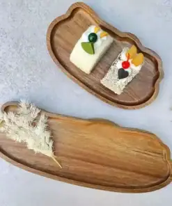 Two cloud-shaped wooden trays, one with cakes, the other with a white dried plant, on a light gray surface. | 28Alchemy
