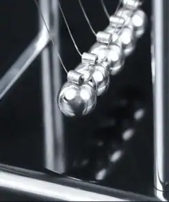 Close-up of a Newton’s cradle with silver metal balls and thin wires, set against a dark background. | 28Alchemy