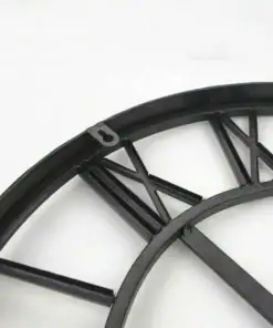Close-up of a black metal clock frame with Roman numerals on a white background. | 28Alchemy