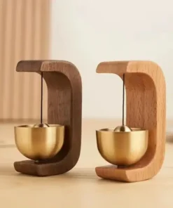 Two small desk bells with wooden frames and brass bowls, one in dark wood and one in light wood, on a wooden surface. | 28Alchemy
