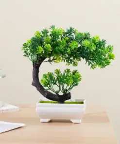 Small artificial bonsai tree with green leaves in a white pot, placed on a wooden tabletop. | 28Alchemy