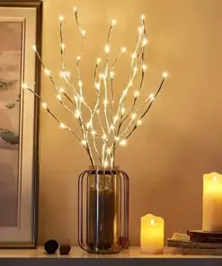 A vase with glowing LED branches beside lit candles and a framed painting on a shelf. | 28Alchemy