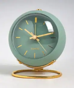 Green round quartz clock with gold hands and stand, showing the time as 9:08, against a light background. | 28Alchemy