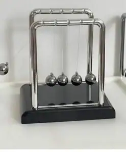 A Newton's cradle with one ball lifted, showing the classic metal balls on a black base. | 28Alchemy